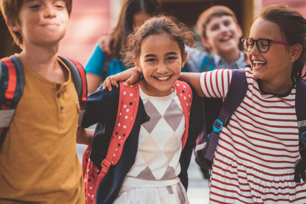 Happy kids with backpacks smiling