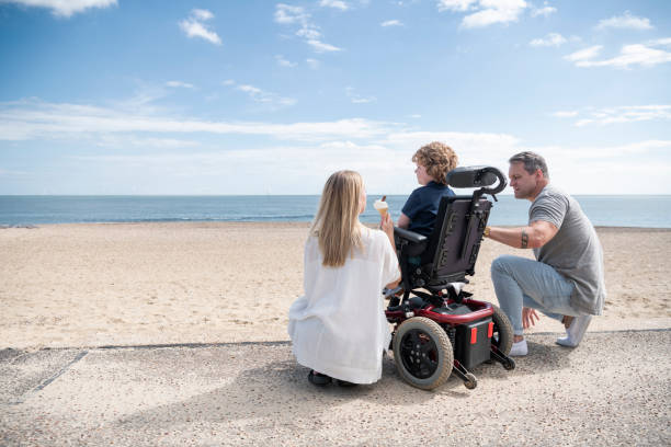 A child in a wheelchair and his parents following a mobility and postural equipment prescription by a childrens physiotherapist